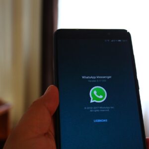 una persona sostiene un teléfono con la aplicación de WhatsApp abierta